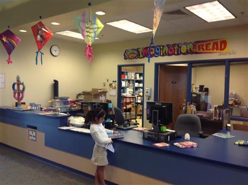 check out desk at bodine library with female student checking out a book 